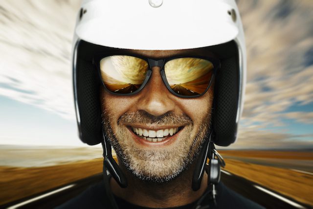 Happy biker on open road. Composite Image, shallow depth of field and grain added